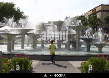 Gdynia, Pologne 9e, juillet 2016 après quelques jours de pluie et de froid, les gens profiter du beau et assez chaud météo à Gdynia, le samedi 9 juillet. Jeune garçon marchant devant fontaine à la place Kosciuszko est vu Crédit : Michal Fludra/Alamy Live News Banque D'Images