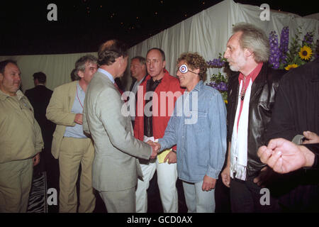 Le Prince de Galles (L) se serre la main avec le chanteur principal de l'OMS Roger Daltrey, alors qu'il rencontre d'autres membres du groupe Pete Townshend (blouson rouge) et John Entwhistle (R) lors d'une réception à la suite de leur représentation au Mastercard Masters of Music concert à Hyde Park à Londres. Banque D'Images