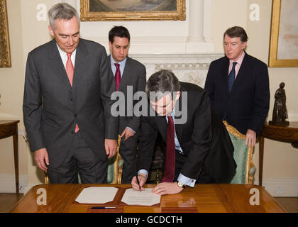 Le Premier ministre Gordon Brown signe un accord sur les énergies à faible émission de carbone sous la surveillance de Peter Loscher (à gauche), président et chef de la direction du géant industriel allemand Siemens AG, Ed Miliband, secrétaire à l'énergie et à l'environnement (deuxième à gauche) et Lord Mandelson, secrétaire aux affaires (à droite), au 10 Downing Street, à Londres. Banque D'Images