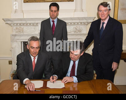 Le Premier ministre Gordon Brown signe un accord sur les énergies à faible émission de carbone sous la surveillance de Peter Loscher (à gauche), président et chef de la direction du géant industriel allemand Siemens AG, Ed Miliband, secrétaire à l'énergie et à l'environnement (deuxième à gauche) et Lord Mandelson, secrétaire aux affaires (à droite), au 10 Downing Street, à Londres. Banque D'Images