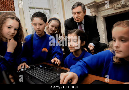 Le Premier ministre Gordon Brown regarde un ordinateur au 10 Downing Street, Londres, avec des écoliers de l'école primaire d'Anson à Cricklewood, dans le nord de Londres, où il a présenté un rapport d'étape sur la façon dont le gouvernement tente de protéger les enfants de l'Internet. Banque D'Images