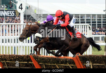 Big Buck, monté par Ruby Walsh (à droite), conduit Rupert, monté par William Kennedy, à gagner l'obstacle Ladbrokes World lors du troisième jour du Cheltenham Festival 2010 à l'hippodrome de Cheltenham. Banque D'Images