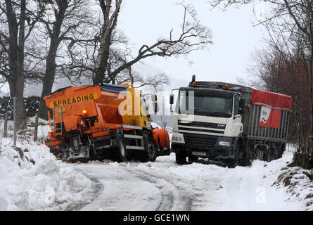 Un camion à tricoter de Stirling council est coincé dans la neige après avoir essayé de passer un camion d'alimentation animale abandonné qui s'est coincé sur la route B818 près de Carronbridge, dans le centre de l'Écosse, après une nuit de neige abondante. Banque D'Images