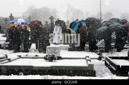 Les gens se dispersent après un enterrement à l'église paroissiale de Killygarry alors que de la neige abondante tombait dans la ville de Cavan, en Irlande. Banque D'Images