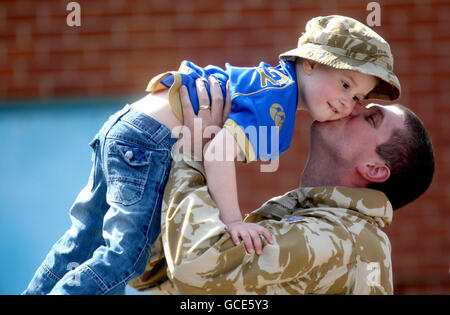 Le sergent d'état-major Jason Coughlan est accueilli par son fils de 3 ans, Aidan, alors que les Medics de l'Armée de terre de l'hôpital Field de 33, le Royal Medical corps revient à fort Blockhouse à Gosport, dans le Hampshire, après une visite en Afghanistan. Banque D'Images