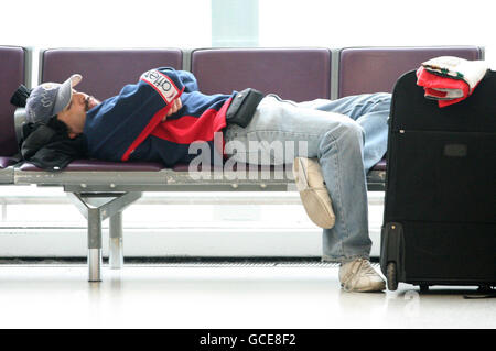 Un passager attend à l'aéroport d'Edimbourg car des restrictions sur les vols à l'entrée et au départ du Royaume-Uni restent en vigueur. Banque D'Images