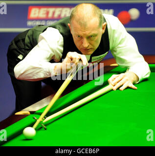 Steve Davis en Angleterre en action contre John Higgins en Écosse lors des championnats du monde de snooker Betfred.com au Crucible Theatre, Sheffield. Banque D'Images