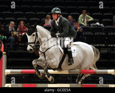 Shane Breen d'Irlande sur la pluie d'or de Mullaghdrin participe à la première partie de ce soir des championnats de saut à l'Open Show britannique au NEC, Birmingham. Banque D'Images