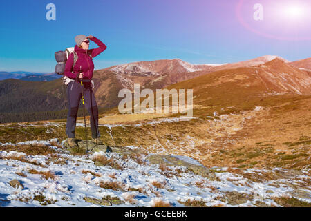 Female Hiker énergique d'un séjour sur terrain enneigé et l'observation d'une vue panoramique sur la montagne Banque D'Images