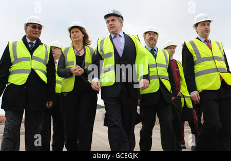 Le Premier ministre Gordon Brown (au centre) et sa femme Sarah marchent jusqu'à Converteam à Rugby, une entreprise qui fabrique des convertisseurs électriques pour les éoliennes. Banque D'Images