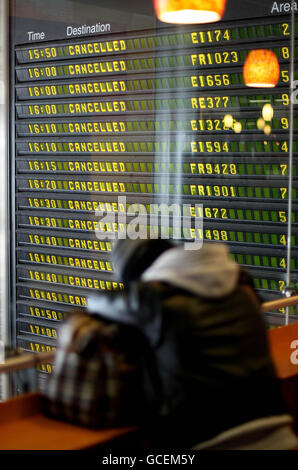 Les cendres volcaniques causent des perturbations de voyage. Un voyageur attend des informations à l'aéroport de Dublin. Banque D'Images