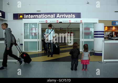 Les enfants attendent à la porte des arrivées de l'aéroport de Newcastle après que le ciel du Royaume-Uni ait rouvert dans un climat de poursuite suite aux restrictions de vol causées par le nuage de cendres volcaniques. Banque D'Images