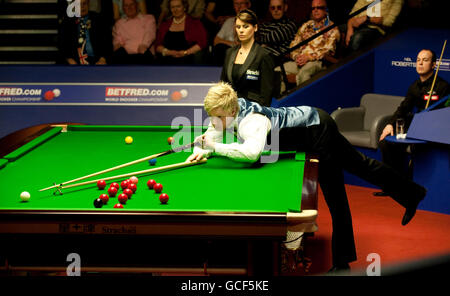 Neil Robertson (à la table) en action contre Fergul O'Brien (à droite) qui regarde pendant les Championnats du monde de Snooker Betfred.com au Crucible Theatre, Sheffield. Banque D'Images