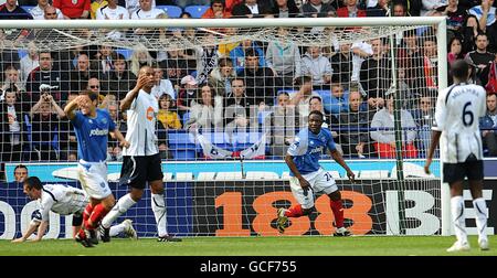 Aruna Dindane (au centre) de Portsmouth célèbre le deuxième but de ses côtés Du jeu comme les joueurs de Bolton Wanderers sont découragés Banque D'Images