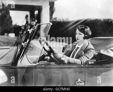 Films silencieux - Bebe Daniels - Hollywood.Bebe Daniels, star de cinéma américaine silencieuse, au volant de sa voiture. Banque D'Images