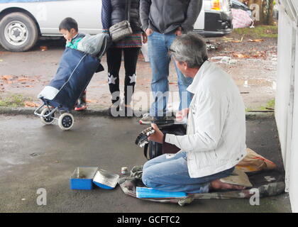 Street musician playing pour une famille Banque D'Images