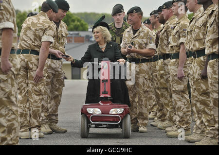 La duchesse de Cornwall roule sur un scooter de mobilité rouge alors qu'elle présente les médailles de campagne de l'Afghanistan aux soldats du 4e Bataillon des fusils à fusil au camp de Bulford, dans le Wiltshire. Banque D'Images