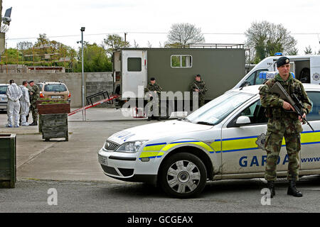 Des membres de l'équipe d'élimination des bombes de l'armée et des médecins légistes de Garda ont été découverts sur le site où deux lance-roquettes chargés, un courant d'assaut et 9 kg de cocaïne ont été cachés dans un entrepôt, près d'une route principale près de Clane, Co Kildare. Banque D'Images