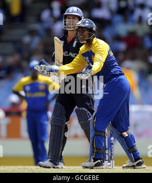Le capitaine du Sri Lankan Kumar Sangakkara change de terrain sous la surveillance du batteur d'Angleterre Michael Lumb lors du match demi-finale de la ICC World Twenty20 au terrain de cricket de Beausejour, à Sainte-Lucie. Banque D'Images