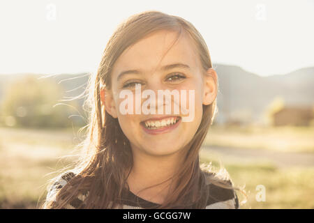 Belle brown-eyed girl smiling dans un champ ensoleillé. Banque D'Images