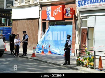 Le couvert devant un magasin de restauration rapide KFC, après qu'un homme a été abattu devant le magasin dans Harrow Road West London, tôt ce matin. Banque D'Images