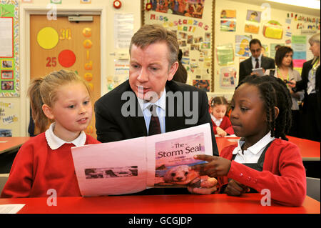 Michael Gove, secrétaire à l'éducation, lit pour Lia Thomas (à gauche) et Chloe Teggart à l'école primaire Cuckoo Hall d'Edmonton, dans le nord-est de Londres, où il a annoncé son intention d'améliorer les normes scolaires. Banque D'Images