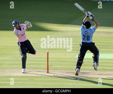 Adam Gilchrist, le gardien de cricket de Middlesex Panthers, observe les requins du Sussex Michael Yardy a frappé le ballon pendant 4 courses lors du match Provident T20 des amis au terrain de cricket de Lord, à Londres. Banque D'Images