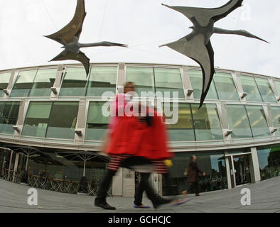 Des piétons marchent sous des ptérosaures modèles suspendus à l'extérieur du Southbank Center, sur la Southbank, dans le centre de Londres. Banque D'Images