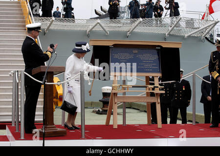 La reine Elizabeth II de Grande-Bretagne dévoile une plaque alors qu'elle quitte le NCSM St John's à la suite d'une revue de la Marine pour souligner le 100e anniversaire de la Marine canadienne, dans les eaux au large de Halifax, en Nouvelle-Écosse, au Canada. Banque D'Images