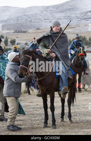 Le prince Harry, lors d'une visite à l'école de garçons de troupeau à Semongkong, au Lesotho, fait un cheval à travers le village accompagné du prince Seeiso du Lesotho. Banque D'Images
