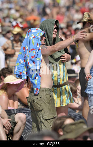 Les fêtards utilisent tout ce qu'ils peuvent pour chercher l'ombre du soleil tandis que les températures montent pendant le festival Glastonbury 2010 à la ferme digne de Pilton, Somerset. Banque D'Images