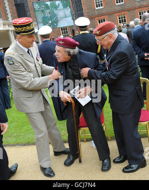 Un général français (à gauche) donne un coup de main au vétéran de la Seconde Guerre mondiale Walter Freegard (au centre), alors qu'il se trouve avec Glynne Medlicott, devant un défilé devant le président français Nicolas Sarkozy et le Premier ministre britannique David Cameron, au Royal Hospital Chelsea à Londres. Banque D'Images