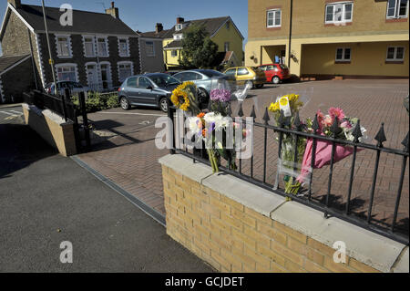 Les hommages floraux sont fixés à des rampes en métal où une jeune fille de cinq ans est décédée après avoir été piégée par une porte coulissante automatique devant Brook court, à Bridgend, au sud du pays de Galles, samedi après-midi. Banque D'Images