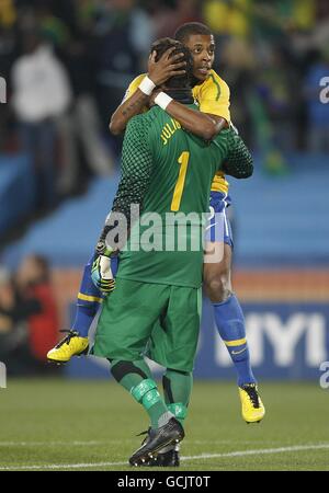 Le brésilien Fernandes Michel Bastos monte sur son gardien de but Soares Julio Cesar en célébration après que leur coéquipier Clemente Luis Fabiano a marqué leur deuxième but. Banque D'Images