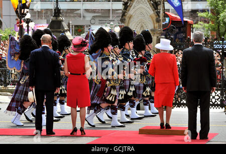 La reine Elizabeth II se trouve à côté du premier ministre canadien Stephen Harper, tandis que le duc d'Édimbourg se tient avec Mme Harper, lors d'une marche de la Garde d'honneur à l'extérieur du Parlement canadien, à Ottawa, au Canada. Banque D'Images