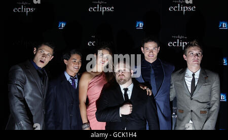 Directeur David Slade (au centre) membres de la troupe (de gauche à droite) Alex Meraz, Booboo Stewart, Nikki Reed, Kellan Lutz, Ashley Greene et Xavier Samuel, alors qu'ils arrivent pour la première de l'éclipse de Twilight Saga, à l'extrémité ouest d'Odeon à Leicester Square, dans le centre de Londres. Banque D'Images