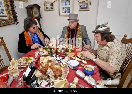 Andy Park (au centre), alias M. Christmas mange son 6000e dîner de Noël avec Mark Smallman (à gauche), alias Mick Jogger, et Tony durant (à droite), alias le Birdman, chez lui à Melksham, dans le Wiltshire. Banque D'Images