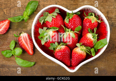 Fraises fraîches dans un bol en forme de coeur. L'alimentation saine. Vue d'en haut Banque D'Images