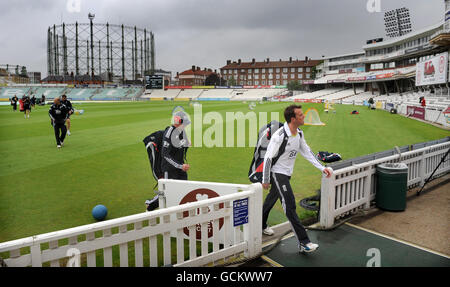 Andrew Strauss (au centre) et Graeme Swann (à droite) quittent le terrain car la pluie cause un retard pendant la session de filets à l'Oval de Brit, Londres. Banque D'Images