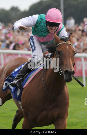 Courses hippiques - Yorkshire Ebor Festival - Darley Yorkshire Oaks and Ladies Day - York Racecourse.Le jockey Tom Queally pats à midi alors qu'ils franchissent la ligne pour gagner les Darley Yorkshire Oaks pendant le festival Ebor à York Racecourse. Banque D'Images