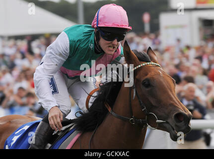 Courses hippiques - Yorkshire Ebor Festival - Darley Yorkshire Oaks and Ladies Day - York Racecourse.Le jockey Tom Queally pats à midi alors qu'ils franchissent la ligne pour gagner les Darley Yorkshire Oaks pendant le festival Ebor à York Racecourse. Banque D'Images