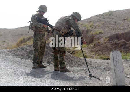 Soldats de la compagnie B les gardes Ecossais vérifient la présence de DEI au cours d'une patrouille le long de la route 601 près de Checkpoint Attal, à 20 milles à l'extérieur de Lashkar Gah dans la province de Helmand, en Afghanistan. Banque D'Images