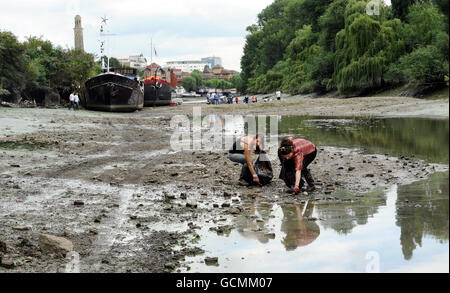 Des bénévoles de Thames21, la principale association caritative de London sur les voies navigables, aident à nettoyer les préphores de la Tamise à Brentford. La zone a une accumulation de sacs en plastique, chariots à provisions, cônes de circulation, pneus et autres déchets. Banque D'Images