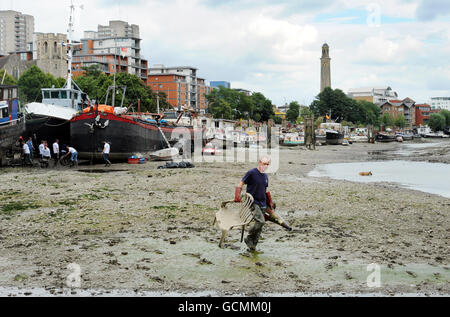 Des bénévoles de Thames21, la principale association caritative de London sur les voies navigables, aident à nettoyer les préphores de la Tamise à Brentford. La zone a une accumulation de sacs en plastique, chariots à provisions, cônes de circulation, pneus et autres déchets. Banque D'Images