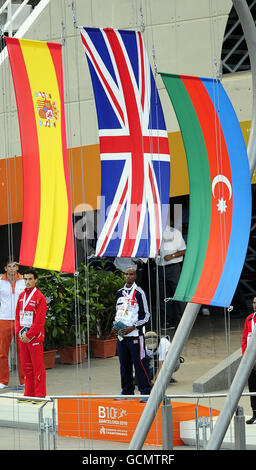 Mo Farah (au centre), en Grande-Bretagne, se dresse sur le podium alors que le drapeau de l'Union est levé et qu'il reçoit sa deuxième médaille d'or pour sa victoire dans la course de 5000m au cours du sixième jour des championnats d'Europe au stade olympique de Barcelone, en Espagne. Banque D'Images