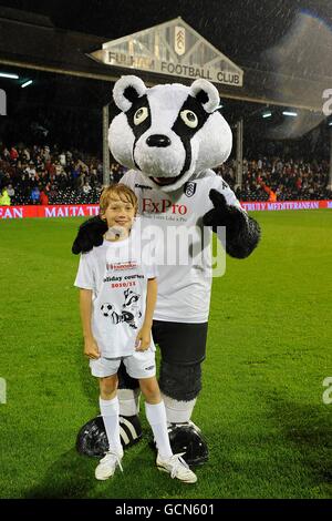 Soccer - Carling Cup - deuxième tour - Fulham v Port Vale - Craven Cottage.Un gagnant du concours pose avec la mascotte de Fulham Billy The Badger à mi-temps Banque D'Images