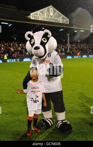 Soccer - Carling Cup - deuxième tour - Fulham v Port Vale - Craven Cottage.Un gagnant du concours pose avec la mascotte de Fulham Billy The Badger à mi-temps Banque D'Images