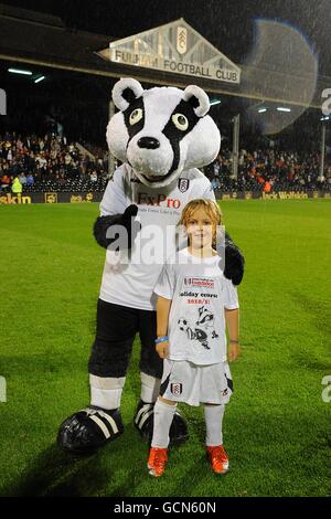 Soccer - Carling Cup - deuxième tour - Fulham v Port Vale - Craven Cottage.Un gagnant du concours pose avec la mascotte de Fulham Billy The Badger à mi-temps Banque D'Images