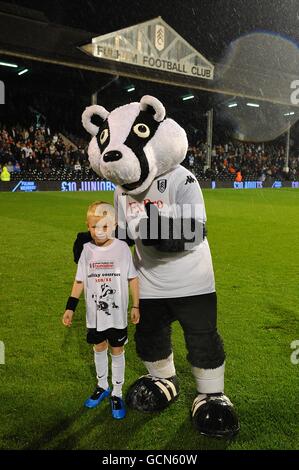 Soccer - Carling Cup - deuxième tour - Fulham v Port Vale - Craven Cottage.Un gagnant du concours pose avec la mascotte de Fulham Billy The Badger à mi-temps Banque D'Images