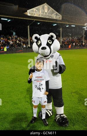 Soccer - Carling Cup - deuxième tour - Fulham v Port Vale - Craven Cottage.Un gagnant du concours pose avec la mascotte de Fulham Billy The Badger à mi-temps Banque D'Images